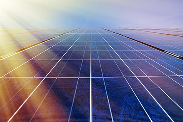 Solar panels and blue sky with sunlight shining on the panels